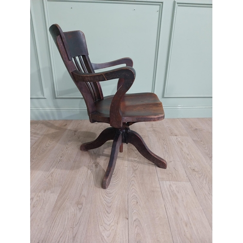 101 - 1950's oak revolving desk chair raised on four shaped outswept feet. {80 cm H x 60 cm W x 60 cm D}.