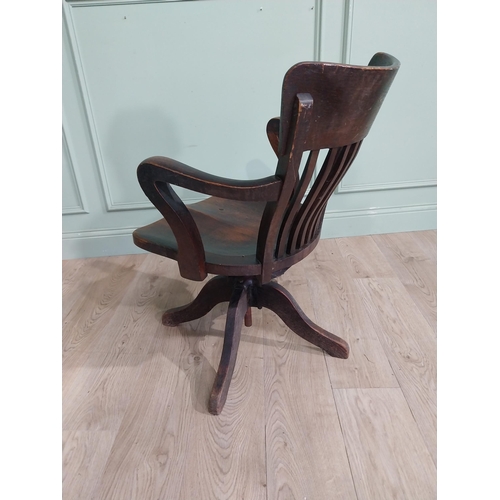 101 - 1950's oak revolving desk chair raised on four shaped outswept feet. {80 cm H x 60 cm W x 60 cm D}.