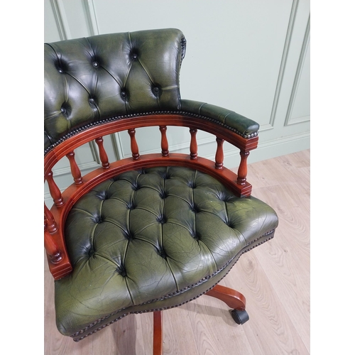 112 - Mahogany revolving desk chair with green leather deep buttoned upholstery raised on four splayed leg... 