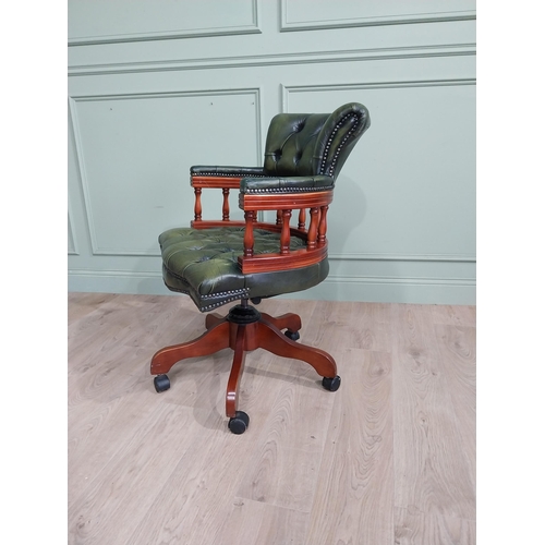 112 - Mahogany revolving desk chair with green leather deep buttoned upholstery raised on four splayed leg... 