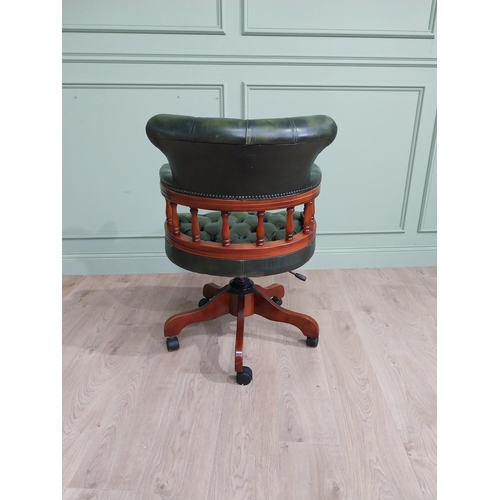 112 - Mahogany revolving desk chair with green leather deep buttoned upholstery raised on four splayed leg... 