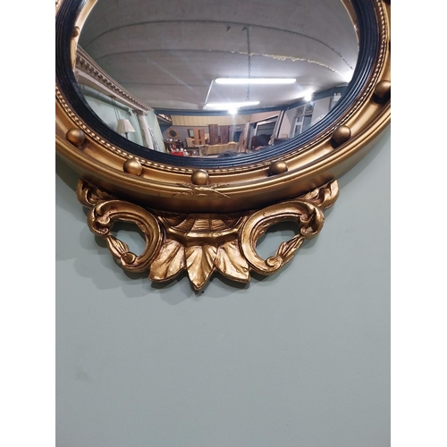 116 - Gilt convex mirror in the Victorian style surmounted by eagle. {79 cm H x 51 cm W}.