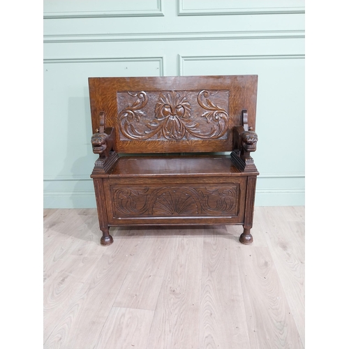 19 - Edwardian carved oak Monks bench with back depicting foliage and arms terminating in animal head rai... 