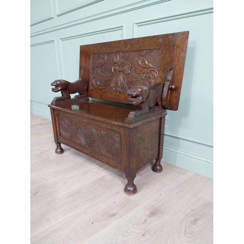 19 - Edwardian carved oak Monks bench with back depicting foliage and arms terminating in animal head rai... 