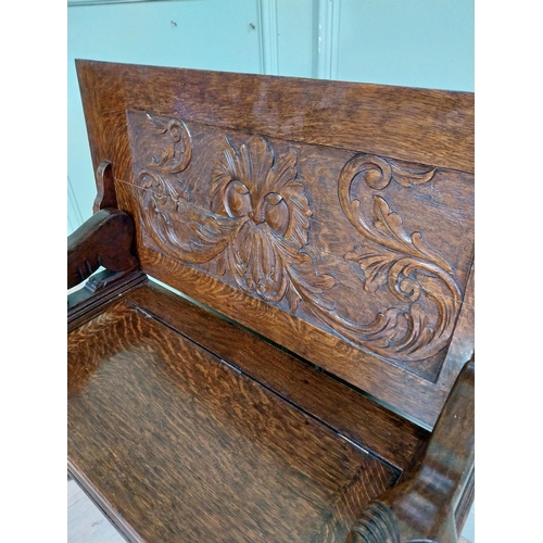 19 - Edwardian carved oak Monks bench with back depicting foliage and arms terminating in animal head rai... 