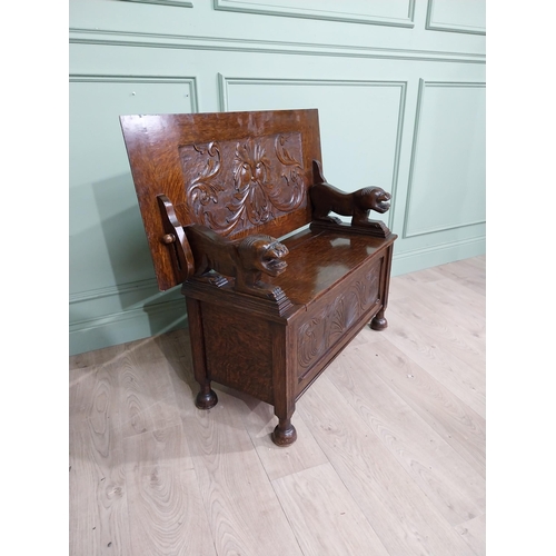 19 - Edwardian carved oak Monks bench with back depicting foliage and arms terminating in animal head rai... 