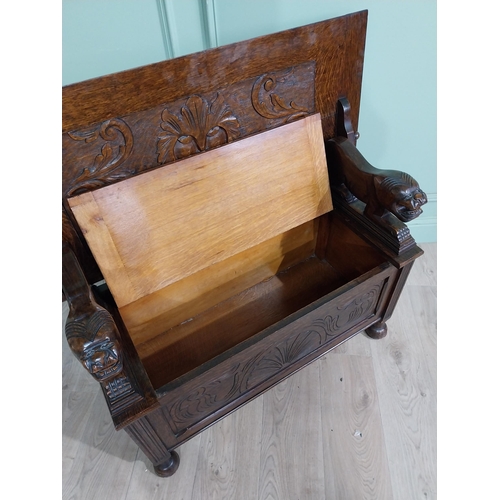 19 - Edwardian carved oak Monks bench with back depicting foliage and arms terminating in animal head rai... 