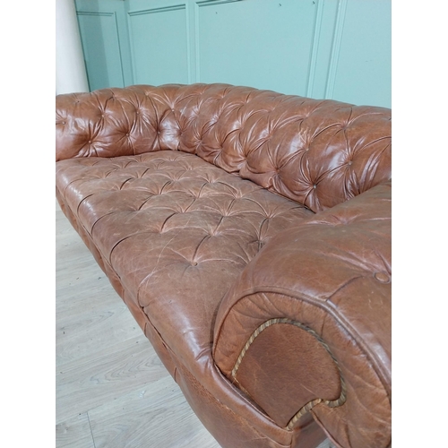 30 - Leather three seater chesterfield sofa. {60 cm H x 193 cm W x 100 cm D}.