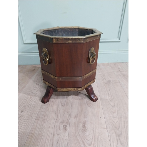 315 - Edwardian mahogany and brass octagonal log bucket with mask handles raised on four paw feet. {41 cm ... 