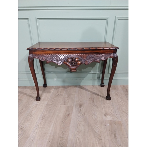 329 - Irish mahogany side table in the Georgian style with carved fruit basket in frieze raised on shaped ... 