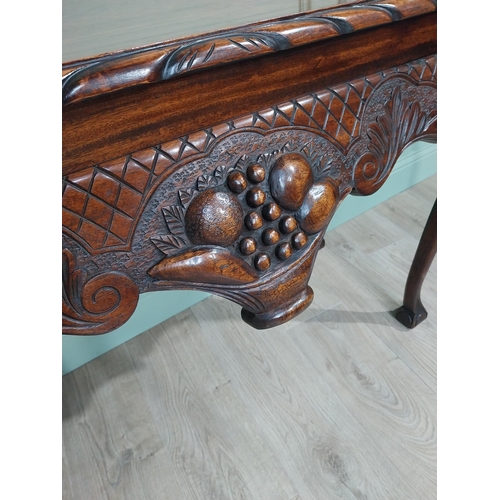 329 - Irish mahogany side table in the Georgian style with carved fruit basket in frieze raised on shaped ... 