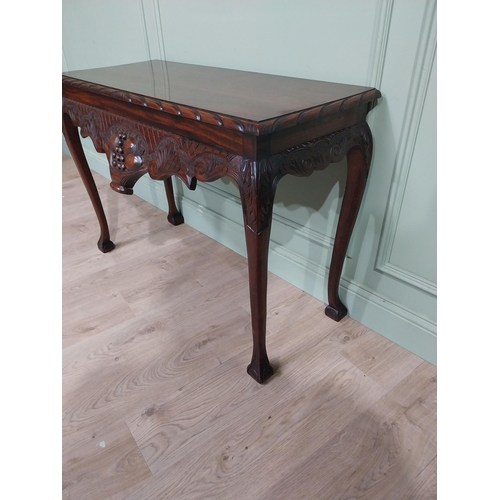 329 - Irish mahogany side table in the Georgian style with carved fruit basket in frieze raised on shaped ... 