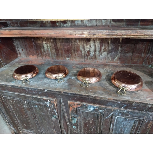 36 - Set of four French copper and brass pans. {5 cm H x 27 cm W x 20 cm D}.