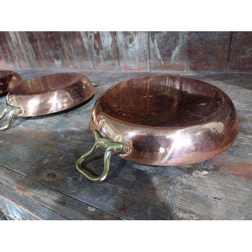 36 - Set of four French copper and brass pans. {5 cm H x 27 cm W x 20 cm D}.