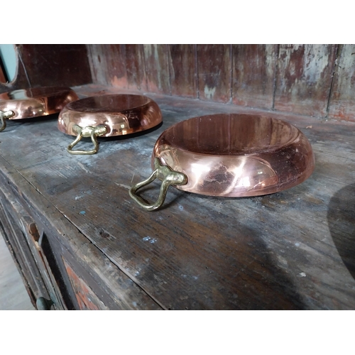 36 - Set of four French copper and brass pans. {5 cm H x 27 cm W x 20 cm D}.