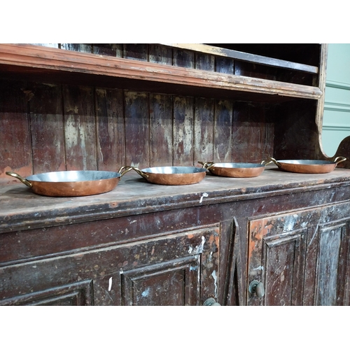 36 - Set of four French copper and brass pans. {5 cm H x 27 cm W x 20 cm D}.