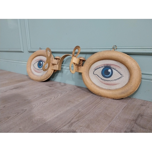 4 - Painted metal optician's sign. {30 cm H x 90 cm W x 15 cm D}.