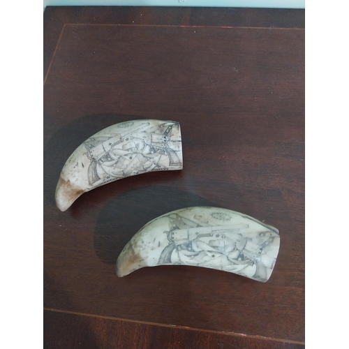 471 - Pair of resin scrimshaw tusks. {16 m H x 6 cm W x 6 cm D}.