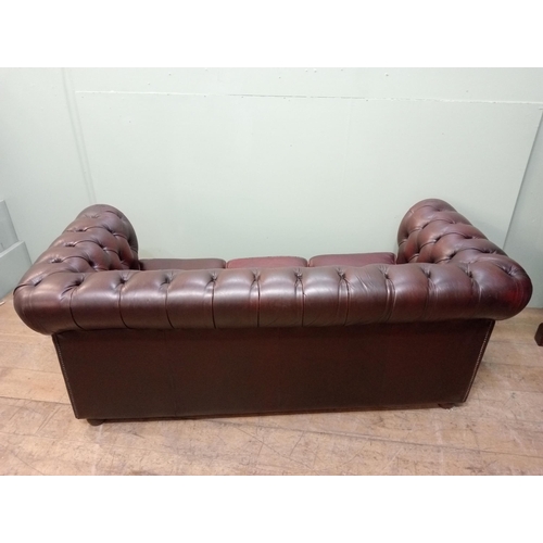 59 - Deep buttoned Chesterfield three seater red leather sofa raised on wooden bun feet  {H 76cm x W 194c... 