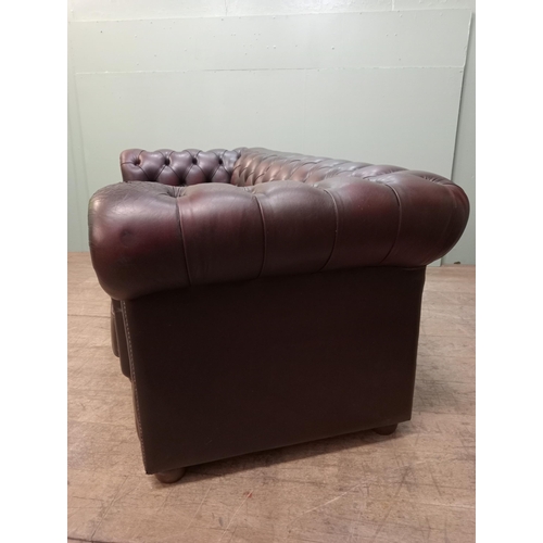 59 - Deep buttoned Chesterfield three seater red leather sofa raised on wooden bun feet  {H 76cm x W 194c... 