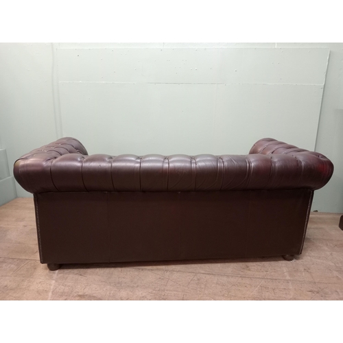 59 - Deep buttoned Chesterfield three seater red leather sofa raised on wooden bun feet  {H 76cm x W 194c... 