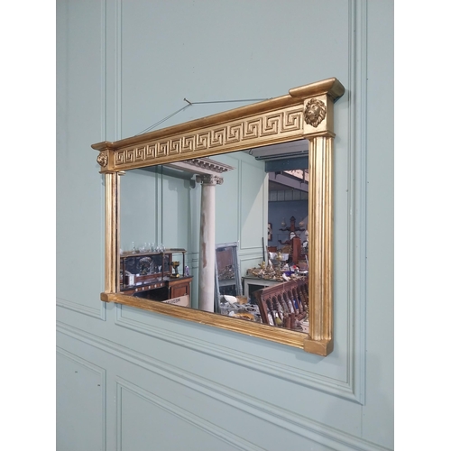 112 - Regency gilt wall mirror flanked by lion�s masks and Grecian key pattern. {64 cm H x 101 cm W}.