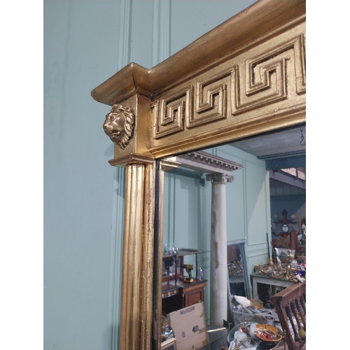 112 - Regency gilt wall mirror flanked by lion�s masks and Grecian key pattern. {64 cm H x 101 cm W}.