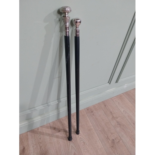 279 - Two silver plate and ebonised walking sticks. {95 cm H} and {90 cm H}.