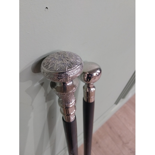 279 - Two silver plate and ebonised walking sticks. {95 cm H} and {90 cm H}.