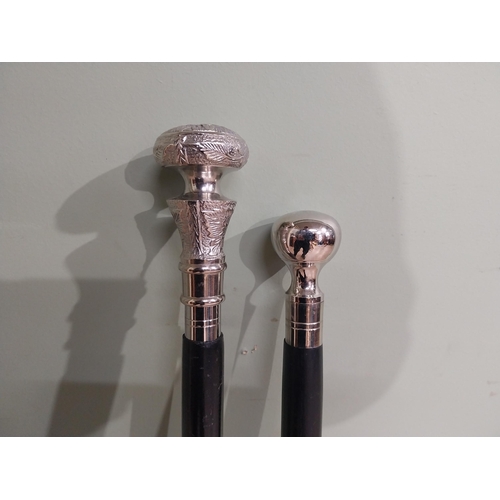 279 - Two silver plate and ebonised walking sticks. {95 cm H} and {90 cm H}.