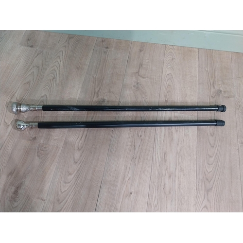 279 - Two silver plate and ebonised walking sticks. {95 cm H} and {90 cm H}.