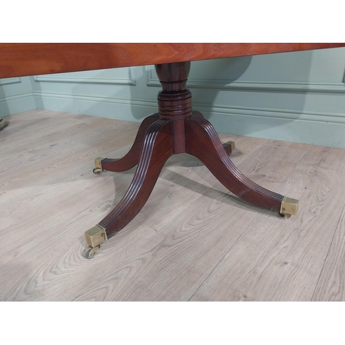 312 - Regency mahogany drop leaf table on single turned column with four reeded outswept feet on castors. ... 