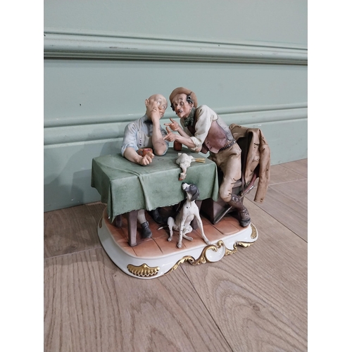 352 - Capodimonte figural group at table. {20 cm H x 24 cm W x 17 cm W}.