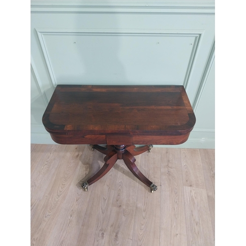 367 - Regency rosewood turn over leaf card table on single turned column with four outswept paw feet and c... 