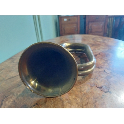 371 - Edwardian brass bugle. {16 cm H x 28 cm W x 10 cm D}.