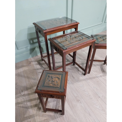 376 - Nest of four carved oriental tables with inset glass tops. {65 cm H x 51 cm W x 36 cm D}.