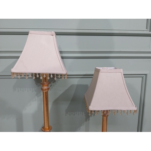 379 - Pair of decorative gilded resin table lamps with cloth shades. {69 cm H and 40 cm H}.