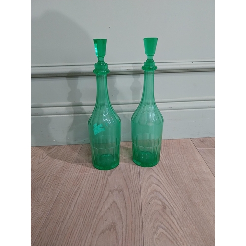 585 - Two green glass decanters. {33 cm H x 7 cm Dia.}.