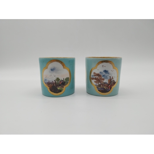 625 - Pair of 20th C. Meissen coffee can cups decorated with three gilt edged cartouches depicting rural s... 