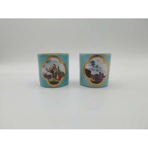 625 - Pair of 20th C. Meissen coffee can cups decorated with three gilt edged cartouches depicting rural s... 