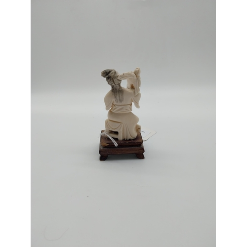 693 - Late 19th C. Chinese carved bone figure on wooden base. {10 cm H}.