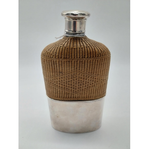 760 - Whiskey hip flask with basket weave wicker half cover and English silver mounts. Hallmarked in Londo... 