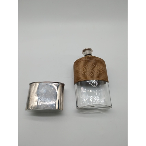 760 - Whiskey hip flask with basket weave wicker half cover and English silver mounts. Hallmarked in Londo... 