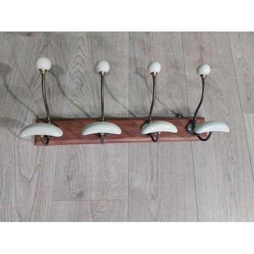 768 - Early 20th C. brass coat hooks mounted on mahogany plaque. [22 cm H x 49 cm W x 14 cm D}.