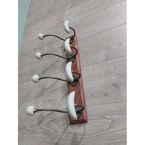 768 - Early 20th C. brass coat hooks mounted on mahogany plaque. [22 cm H x 49 cm W x 14 cm D}.