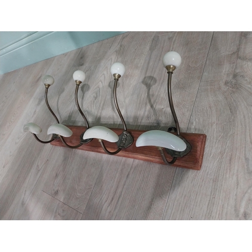 768 - Early 20th C. brass coat hooks mounted on mahogany plaque. [22 cm H x 49 cm W x 14 cm D}.