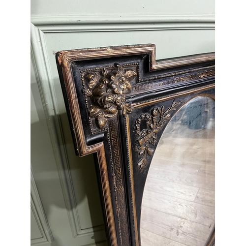 80a - Gilded ebonised wall mirror with oval plate, in the Victorian style. { 105cm H X 71cm W }.