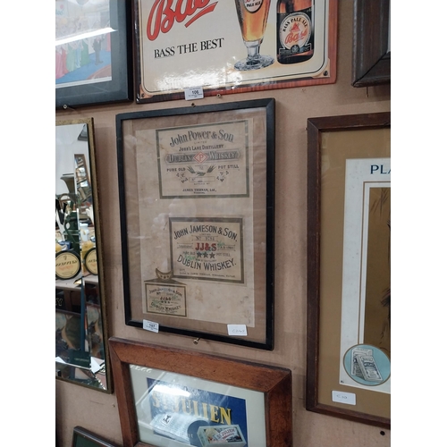 107 - Framed collection of three John Jameson and John Powers Whiskey labels. {44 cm H x 35 cm W}.