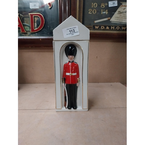 113 - Ceramic bottle in the form of Coldstream Guard. {25 cm H x 9 cm W x 9 cm D}.