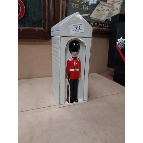 113 - Ceramic bottle in the form of Coldstream Guard. {25 cm H x 9 cm W x 9 cm D}.